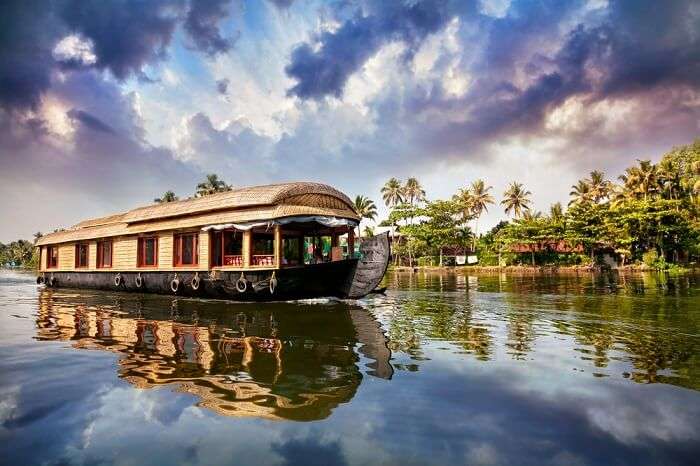 A houseboats in Alleppey traversing the deep blue backwaters