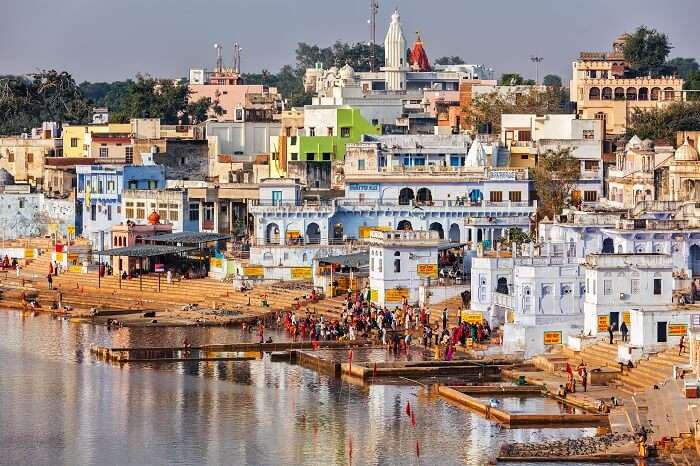 Hindu devotees pilgrims bathing in sacred Puskhar lake on ghats of Pushkar