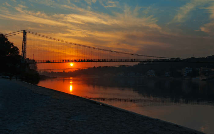 View of River Ganga and Ram Jhula bridge at sunset. Rishikesh. India