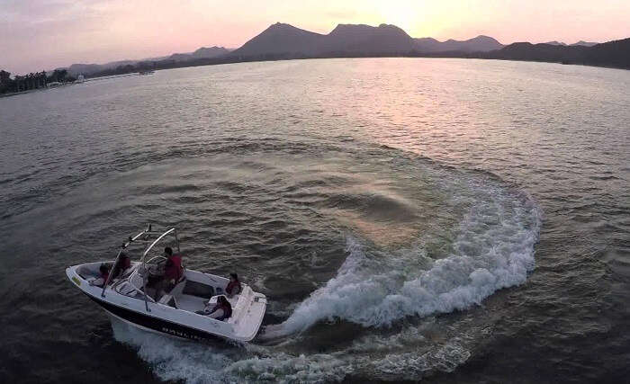 A couple of tourists enjoying the thrills of motor boating in Rajasthan at Fateh Sagar Lake