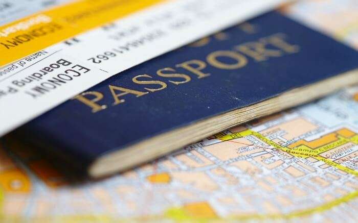 Passport and flight tickets lying on a map