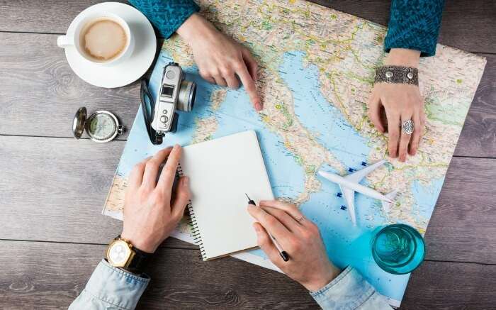A man and woman planning a trip with a map