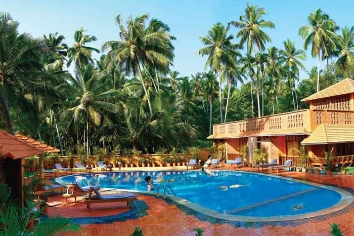 Tourists relaxing at the swimming pool of the Beach and Lake Resort in Kerala