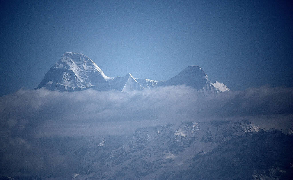 a snow covered mountain visible through floating mist