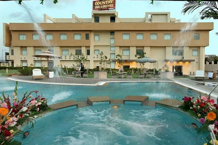 The swimming pool and hotel building at Country Inn in Ajmer