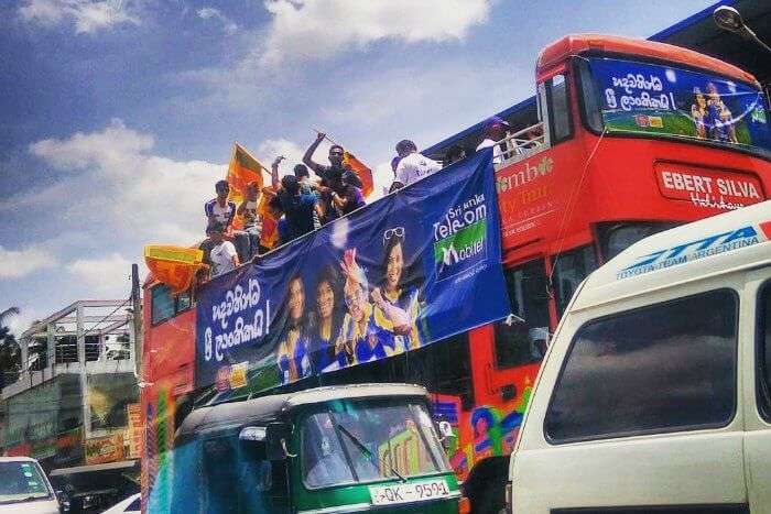 sri lankan cricket fans cheering for their team atop a bus