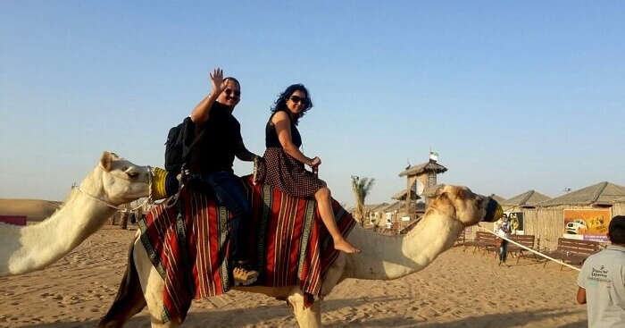 Roshan and his wife riding a camel in Dubai