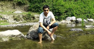 Tushar sitting by a stream during his trip to Lansdowne