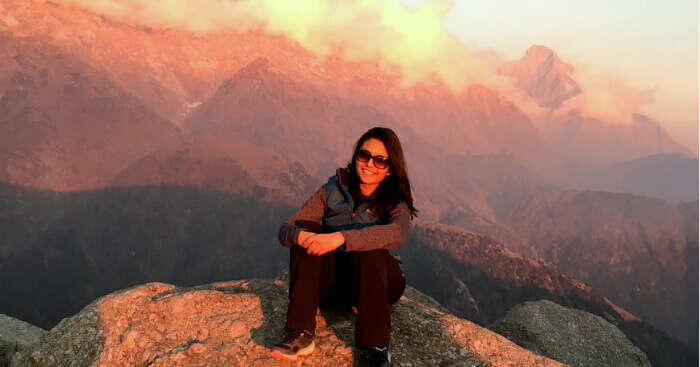 Tejal sitting on a cliff during her weekend trip to Mcleodganj
