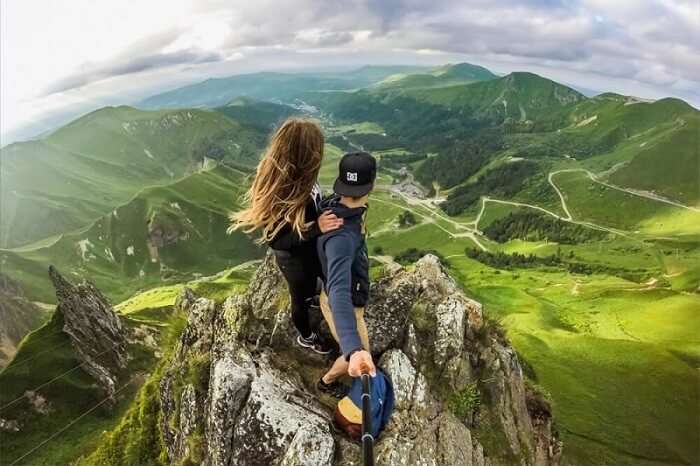 A daring couple on mountain top