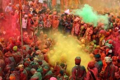 People throw colors to each other during the Holi celebration at Krishna temple