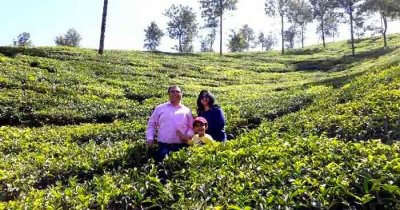 A family standing amidst tea plantation in Kerala