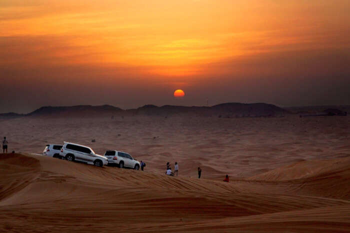 Travelers watching sunrise during desert safari in Dubai, one of the best international honeymoon destinations on your budget