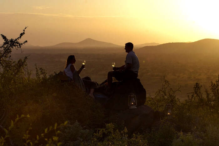 Couple drinking wine during their safari honeymoon in South Africa