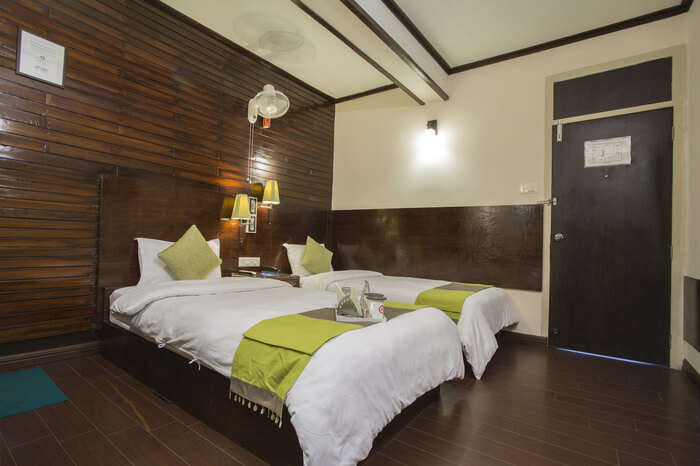 two beds in a wooden floor hotel room