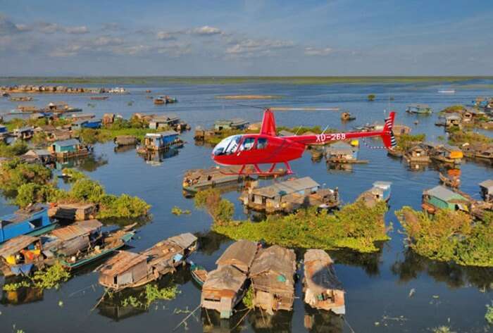 A helicopter flying over the floating villages of Tonle Sap Lake in Siem Reap