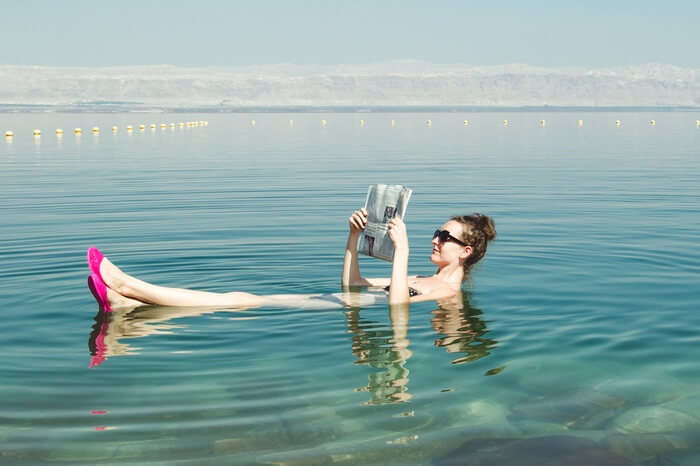 A woman reading newspapaer while floating in the Dead Sea