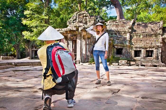 Beautiful young couple at Prasat Ta Prum or Ta Prohm Temple complex in Siem Reap