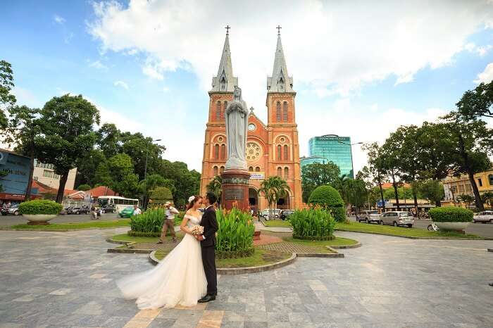 A newlywed couple taking pictures outside the Notre Dame Cathedral in Ho Chi Minh city in Vietnam