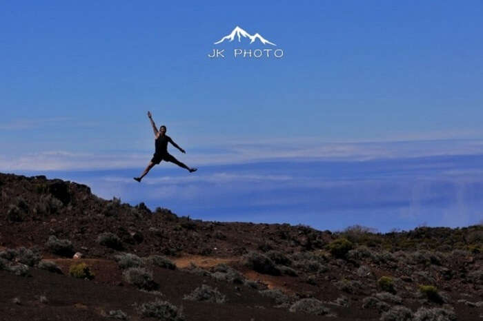 man jumps near a volcano in Reunion Island, France