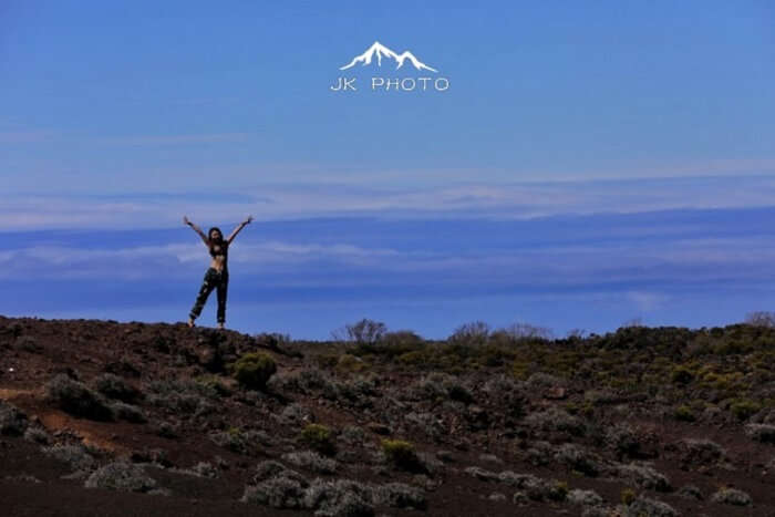 female jumps near a volcano in Reunion Island, France