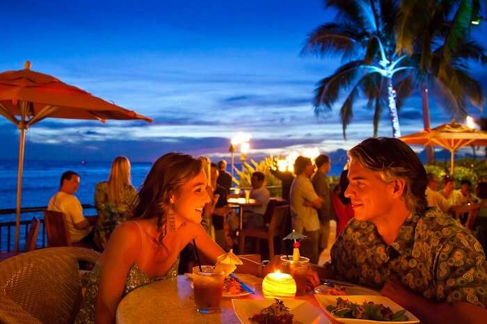 A couple enjoying a romantic candle-lit dinner in Hawaii