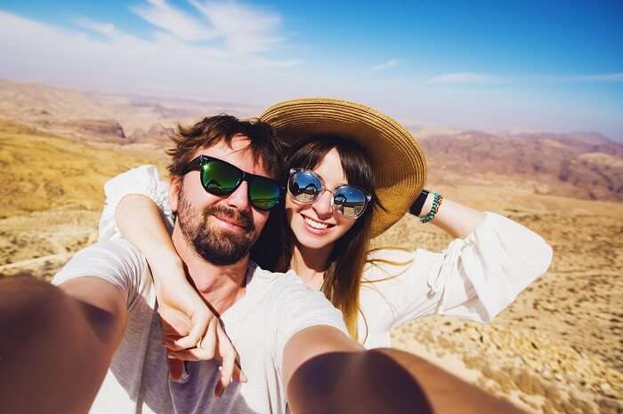Young travel couple taking selfie after a trek on their Jordan honeymoon