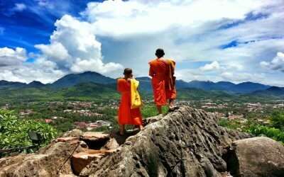 two Buddhist monks standing on a hill