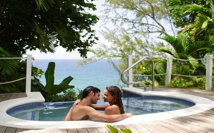 A couple in a pool overlooking Caribbean Sea