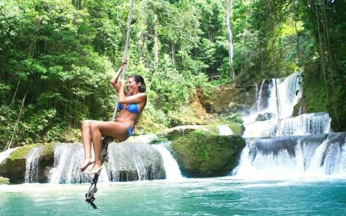 A woman swinging on a rope in Black River 