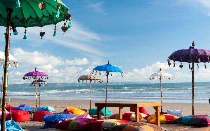 Colourful bean bags with a wooden table on Kuta beach SS20052017