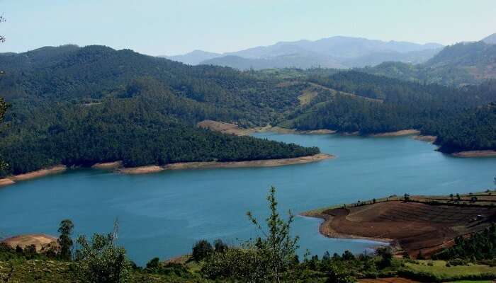 Emerald Dam and Lake meandering through Nilgiri mountains , one of the best honeymoon places in Ooty