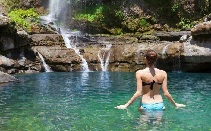Woman enjoying a dip in a waterfall in Sagada
