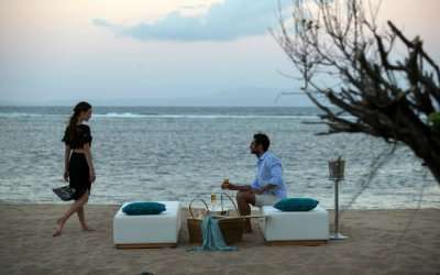 A honeymoon couple enjoying drinks on a beach