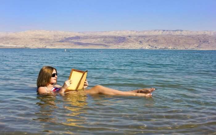 A woman reading a book in Dead Sea in Jordan