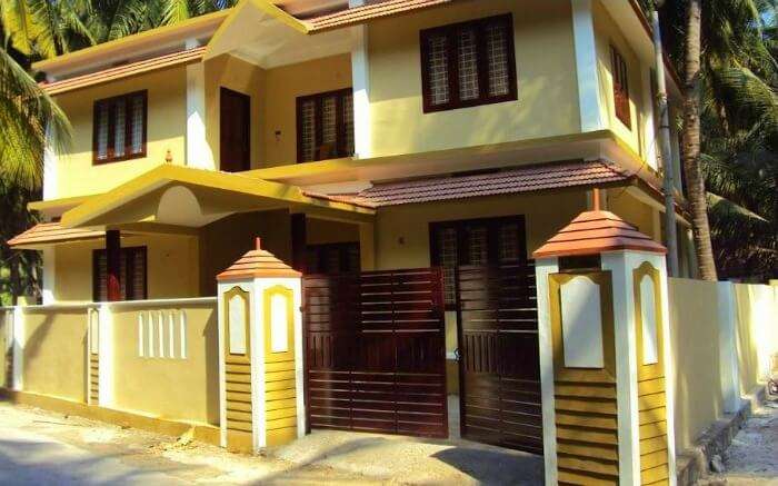 A yellow colour house with a red iron gate on Agatti Island