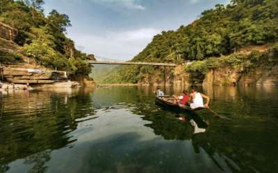 Kids rowing a boat in a river of Meghalaya, one of the Seven Sisters of India