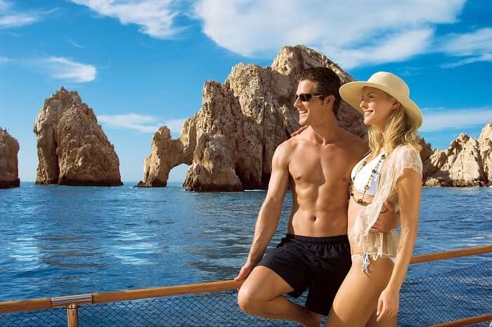 A couple on a honeymoon in Mexico taking a cruise ride near El Arco de Cabo San Lucas at Los Cabos