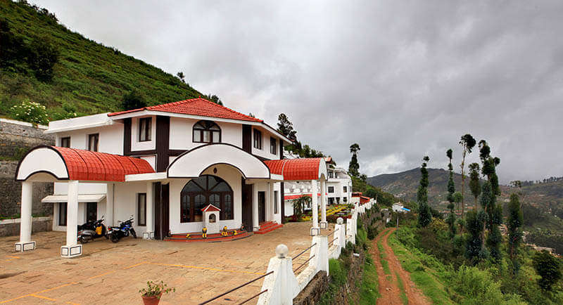 a red and white resort in the foggy hills of Kodaikanal