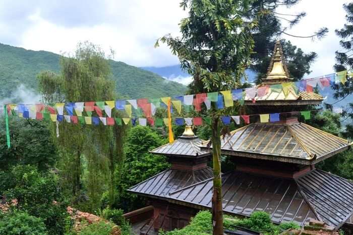 A pagoda style temple with colourful flags tied around