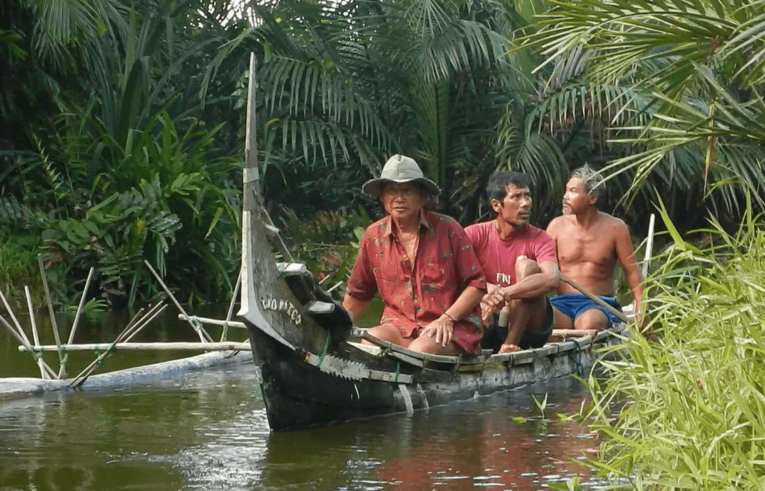 three men rowing a boat in water