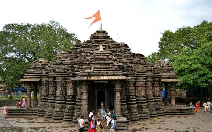 An ancient temple with an orange flag on top of 