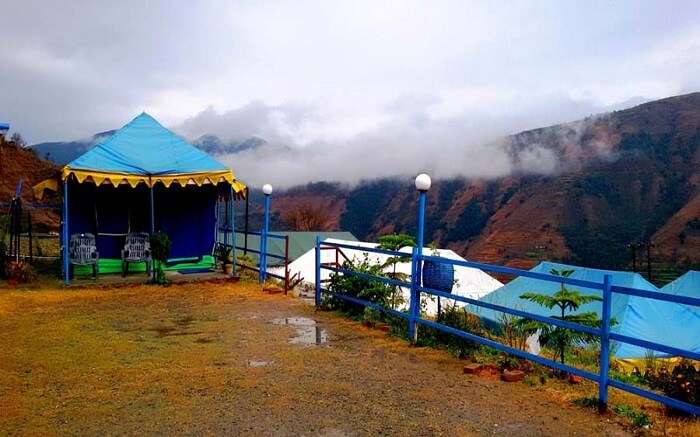 Blue colour tent in a ground in misty mountains 