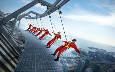 People wearing red clothes hanging from Macau Tower