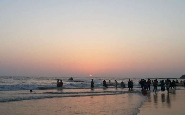 A mesmerising view of people at a beach during sunset in Alibaug, one of the best places to visit in winter in India