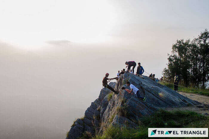 a group of people rock climbing in M