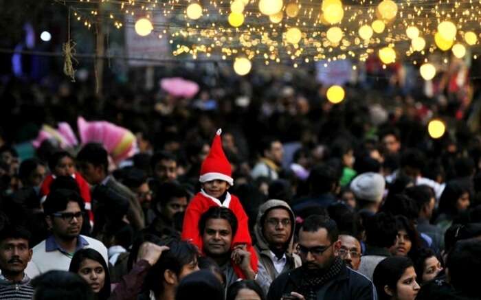 A child sitting on the shoulder of his parents in Janpath Christmas market in Delhi