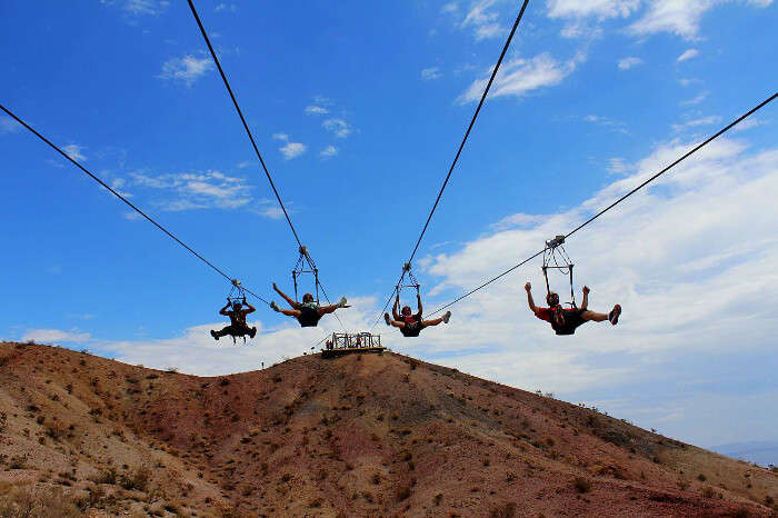 four men zip lining in grand canyon