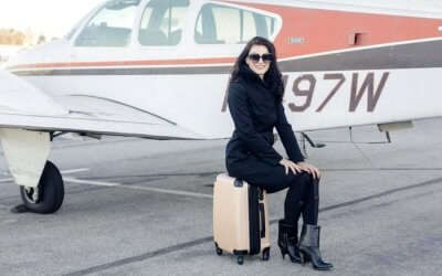 Jill Paider posing for a photograph on her suitcase