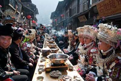 a bunch of people eating on a long table on valentines day, one of the valentine's day traditions around the world